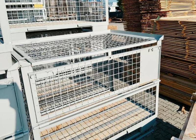 Galvanised containers stacked with the gate lowered for picking
